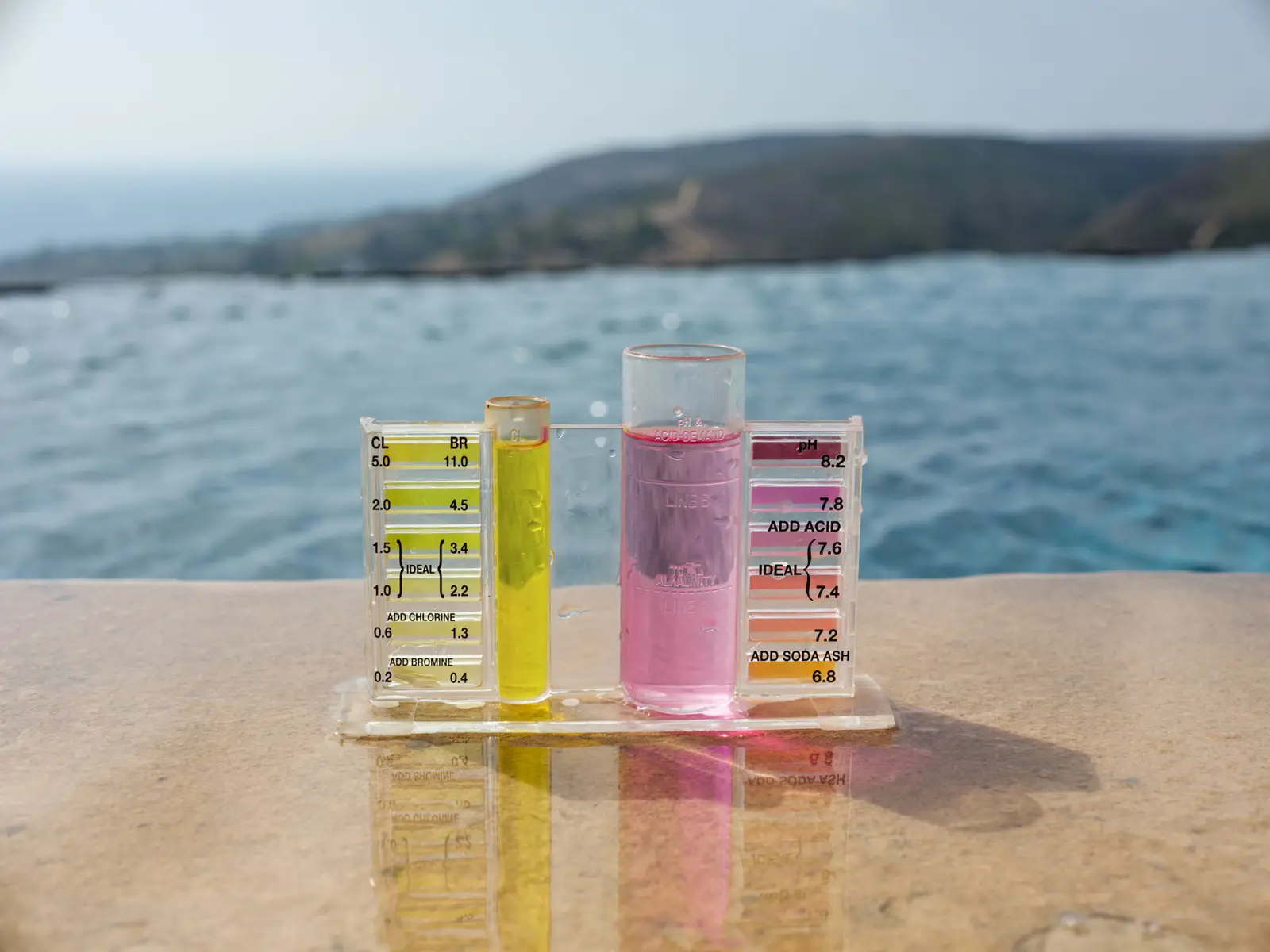 Radiant water test kit on a pool edge overlooking the Orange County coast